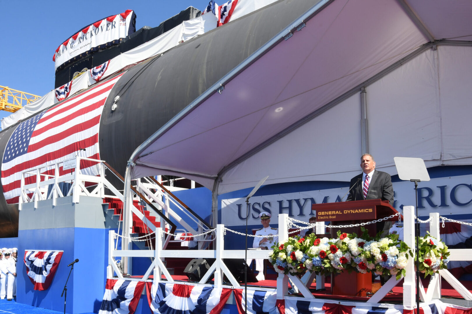 210731-N-GR655-113 GROTON, Conn. (July 31, 2021) – Under Secretary of the Navy James Geurts delivers remarks in front of the pre-commissioning unit (PCU) Hyman G. Rickover (SSN 795) during a christening ceremony at General Dynamics Electric Boat shipyard facility in Groton, Conn., July 31, 2021. Rickover and crew will operate under Submarine Squadron (SUBRON) FOUR whose primary mission is to provide attack submarines that are ready, willing, and able to meet the unique challenges of undersea combat and deployed operations in unforgiving environments across the globe. (U.S. Navy photo by Chief Petty Officer Joshua Karsten/RELEASED)